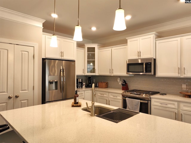 kitchen featuring appliances with stainless steel finishes, backsplash, crown molding, and pendant lighting