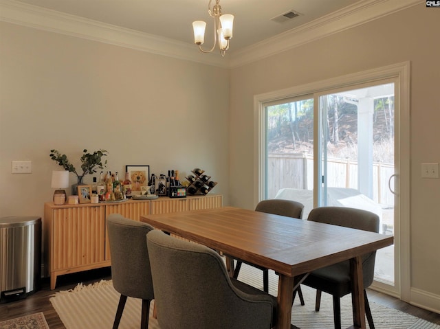 dining space featuring ornamental molding, dark hardwood / wood-style flooring, and a notable chandelier