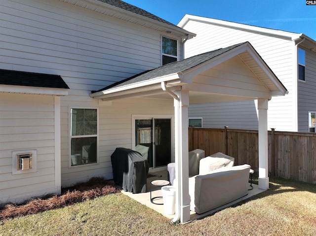 exterior space with a yard, roof with shingles, and fence