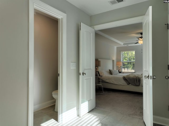 bedroom with connected bathroom, ceiling fan, and light tile patterned floors