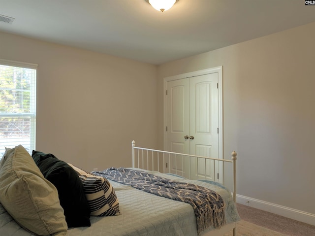 bedroom with a closet and light colored carpet