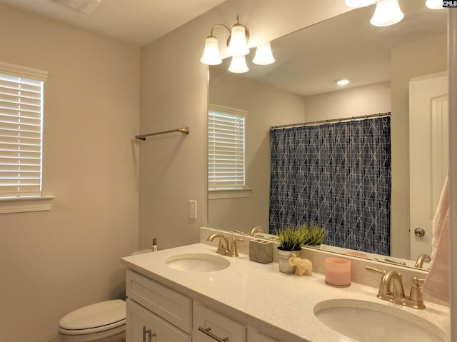 bathroom with toilet, curtained shower, double vanity, and a sink