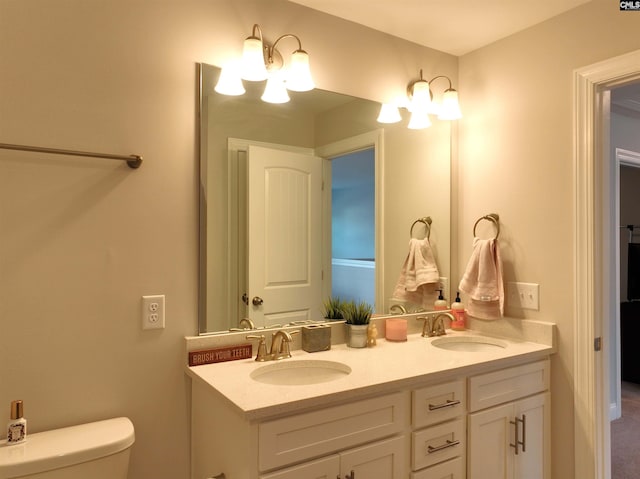 full bathroom with double vanity, a sink, and toilet