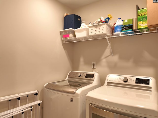 washroom with cabinets and washing machine and clothes dryer