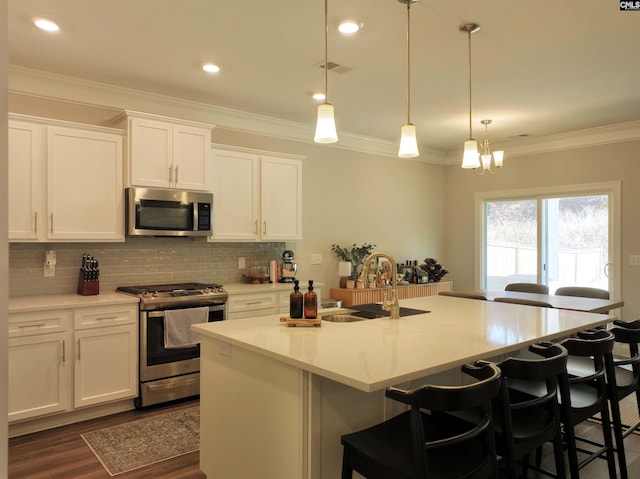 kitchen with white cabinets, stainless steel appliances, and a kitchen island with sink