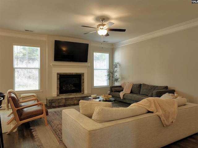 living room featuring ceiling fan, plenty of natural light, wood-type flooring, and ornamental molding