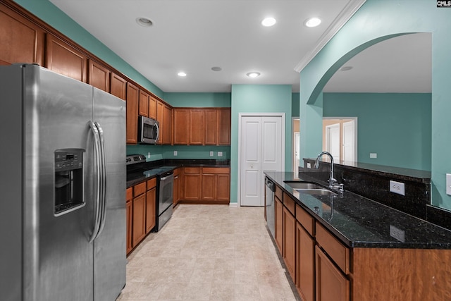 kitchen featuring stainless steel appliances, dark stone countertops, and sink