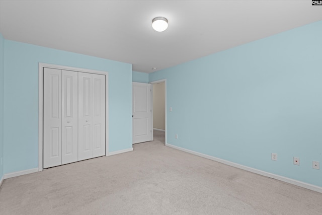 unfurnished bedroom with light carpet and a closet