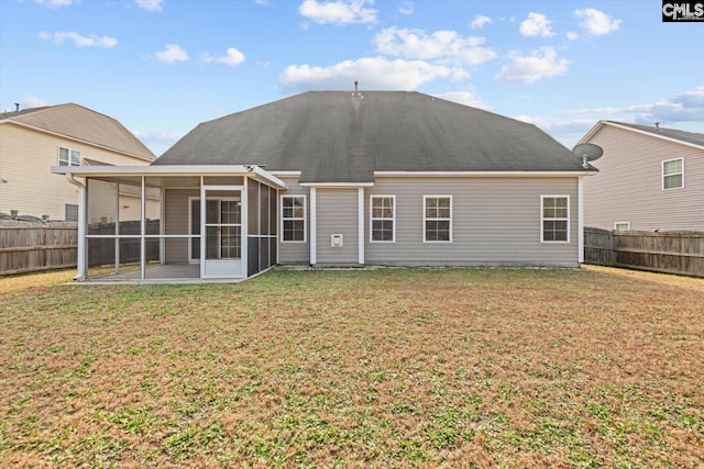 back of house featuring a sunroom, a patio area, and a lawn