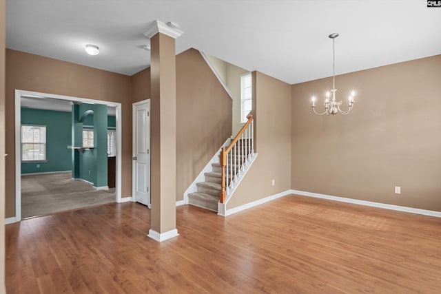 spare room with a chandelier and hardwood / wood-style flooring