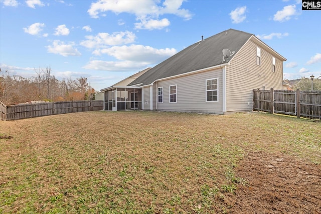 back of property with a yard and a sunroom