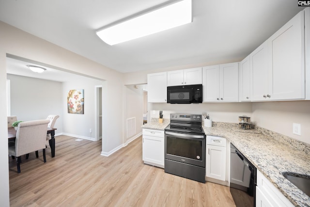 kitchen with black appliances, light stone countertops, light wood-type flooring, and white cabinetry