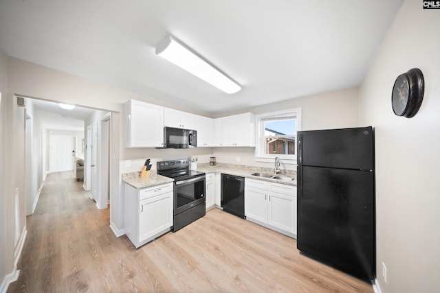 kitchen featuring black appliances, white cabinets, sink, light hardwood / wood-style floors, and light stone counters