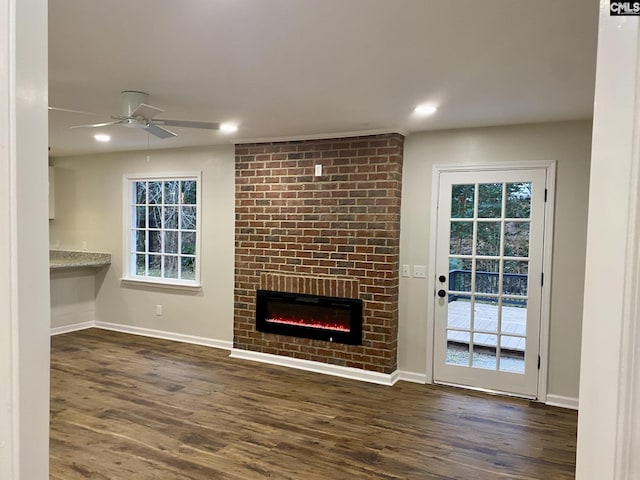 unfurnished living room with ceiling fan, dark hardwood / wood-style flooring, and a fireplace