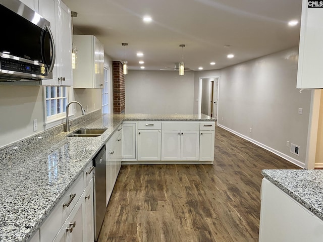 kitchen with pendant lighting, white cabinetry, dark hardwood / wood-style flooring, kitchen peninsula, and stainless steel appliances