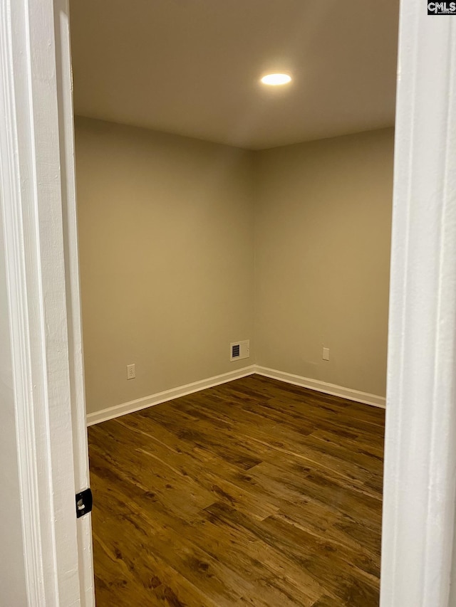 unfurnished room with dark hardwood / wood-style flooring