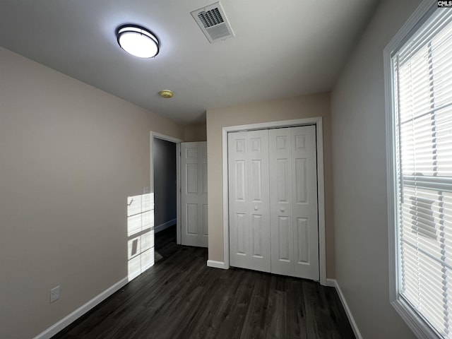 unfurnished bedroom featuring dark hardwood / wood-style floors and a closet