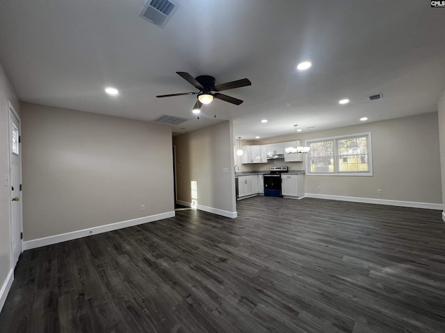 unfurnished living room featuring ceiling fan with notable chandelier and dark hardwood / wood-style floors