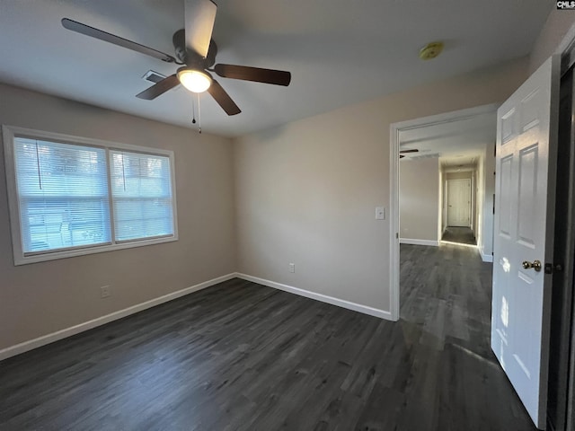 unfurnished room with dark hardwood / wood-style flooring and ceiling fan