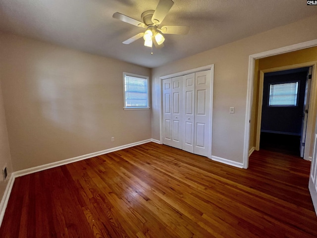 unfurnished bedroom featuring ceiling fan, a closet, and dark hardwood / wood-style floors