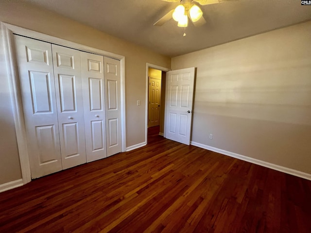 unfurnished bedroom with ceiling fan, a closet, and dark wood-type flooring