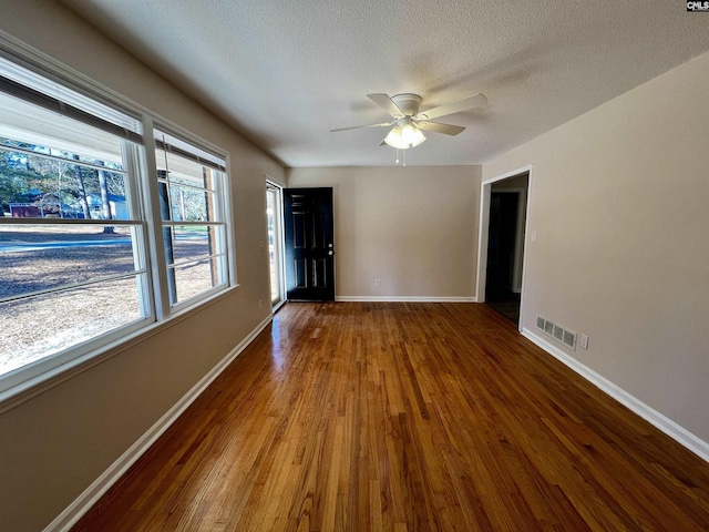 spare room featuring ceiling fan, wood-type flooring, and a textured ceiling