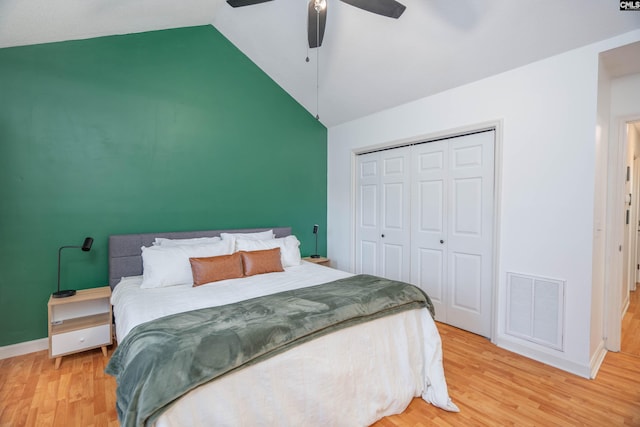 bedroom with hardwood / wood-style floors, a closet, ceiling fan, and lofted ceiling