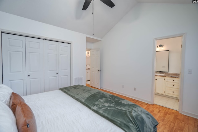 bedroom with ensuite bath, ceiling fan, high vaulted ceiling, a closet, and light wood-type flooring