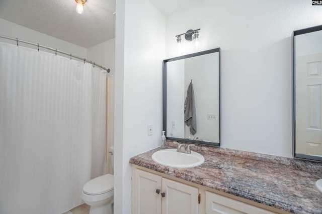 bathroom with vanity, a textured ceiling, and toilet