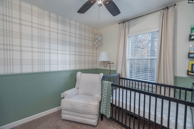 bedroom with carpet, ceiling fan, and a nursery area