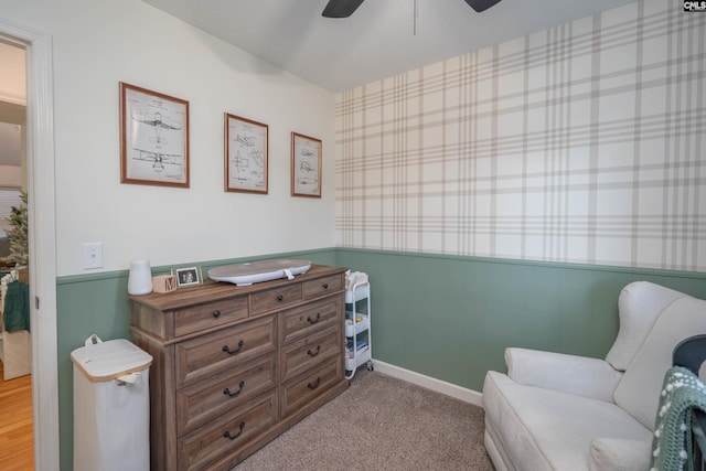 living area with light carpet and ceiling fan