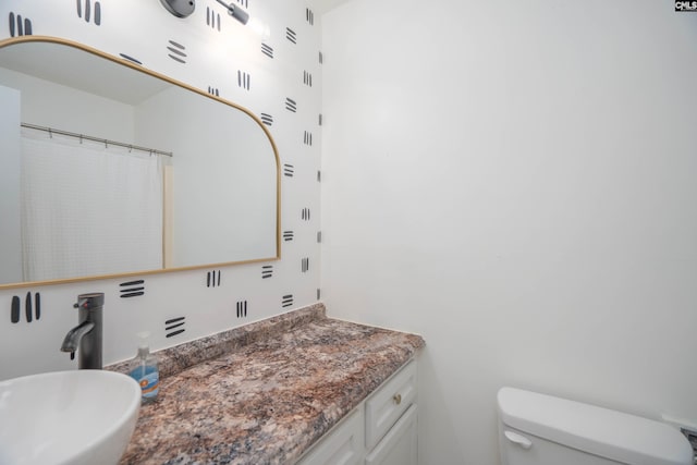 bathroom with vanity, toilet, and curtained shower