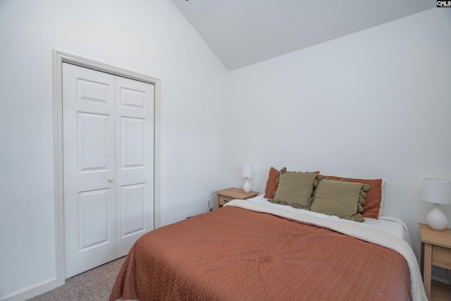 bedroom with carpet flooring, a closet, and lofted ceiling