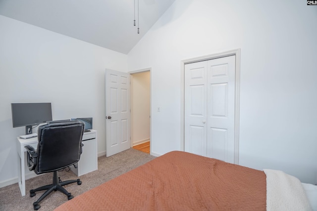 carpeted bedroom with high vaulted ceiling and a closet