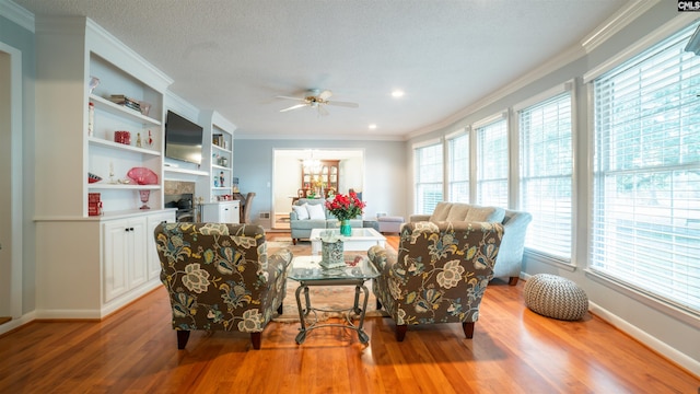 living room featuring a healthy amount of sunlight, light wood-type flooring, and ornamental molding