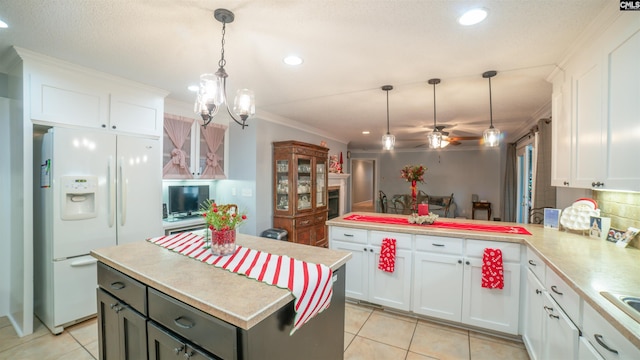 kitchen with white cabinets, pendant lighting, and white refrigerator with ice dispenser