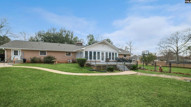 rear view of property featuring a lawn, central AC unit, and a wooden deck