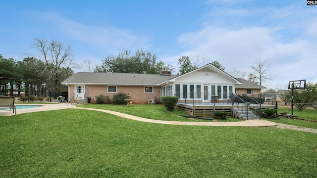 rear view of property with central AC unit, a pool side deck, and a yard