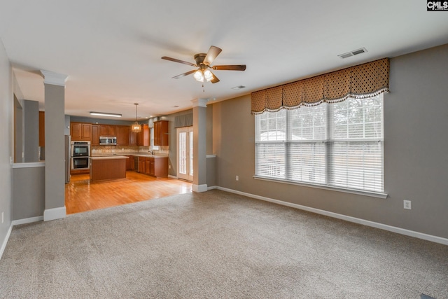 unfurnished living room with ceiling fan, sink, and light hardwood / wood-style floors