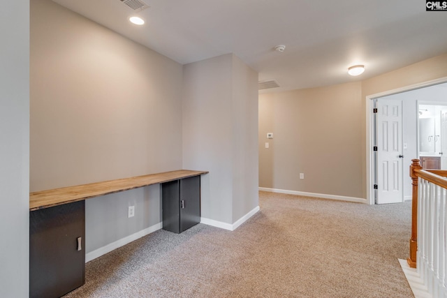 unfurnished office featuring carpet flooring and built in desk