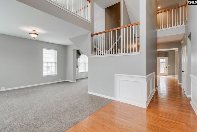 stairway featuring a high ceiling and hardwood / wood-style floors