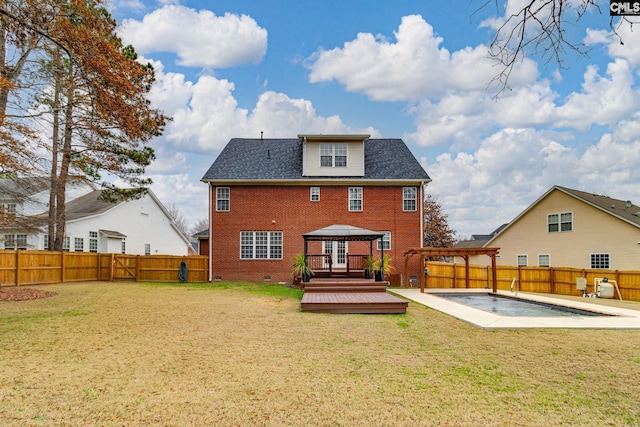 rear view of property featuring a gazebo, a swimming pool side deck, and a lawn