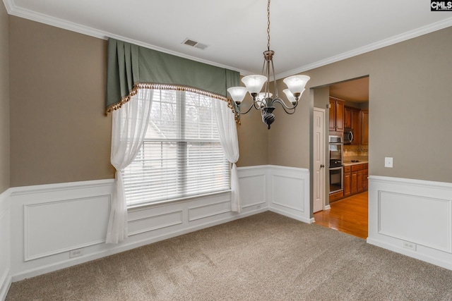 spare room featuring ornamental molding, light carpet, and a chandelier