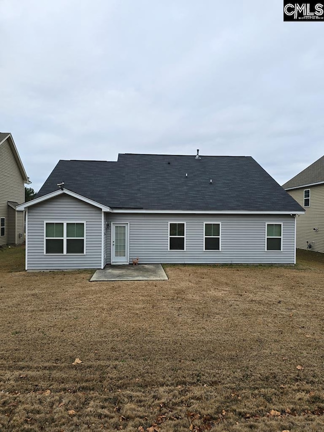 back of house with a patio and a lawn