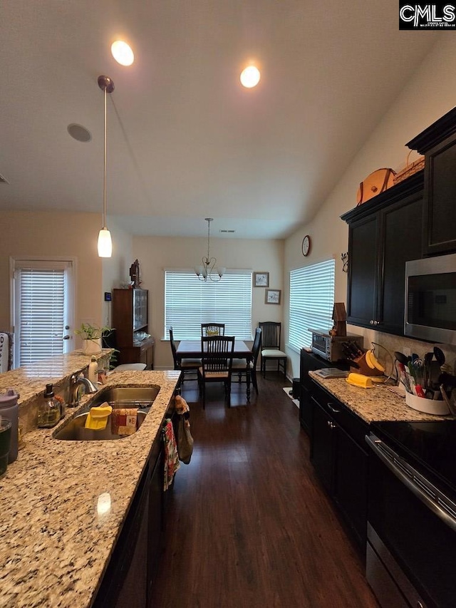 kitchen featuring appliances with stainless steel finishes, sink, decorative light fixtures, dark hardwood / wood-style floors, and plenty of natural light