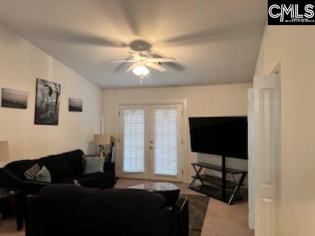 carpeted living room with ceiling fan and french doors