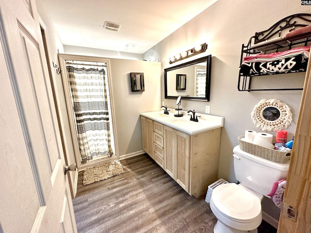 bathroom featuring a shower with shower curtain, vanity, toilet, and wood-type flooring