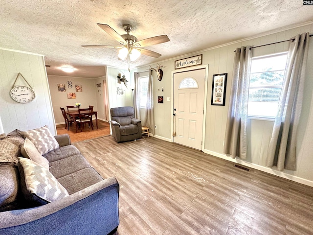 living room featuring ceiling fan, ornamental molding, and hardwood / wood-style flooring