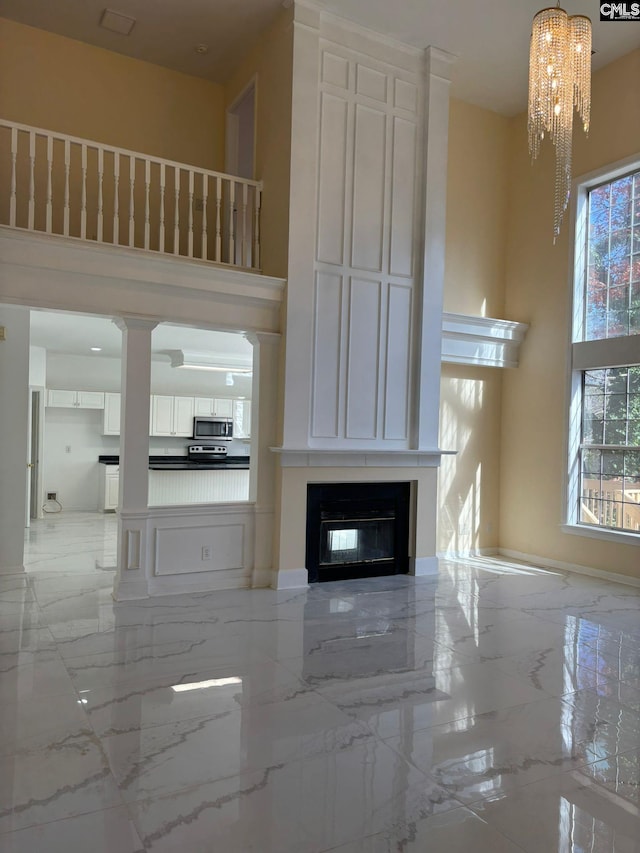 unfurnished living room with a notable chandelier and a towering ceiling