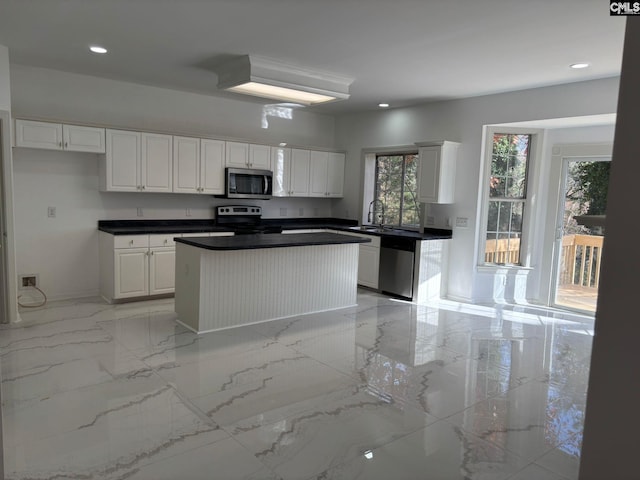 kitchen featuring stainless steel appliances, white cabinetry, and a kitchen island